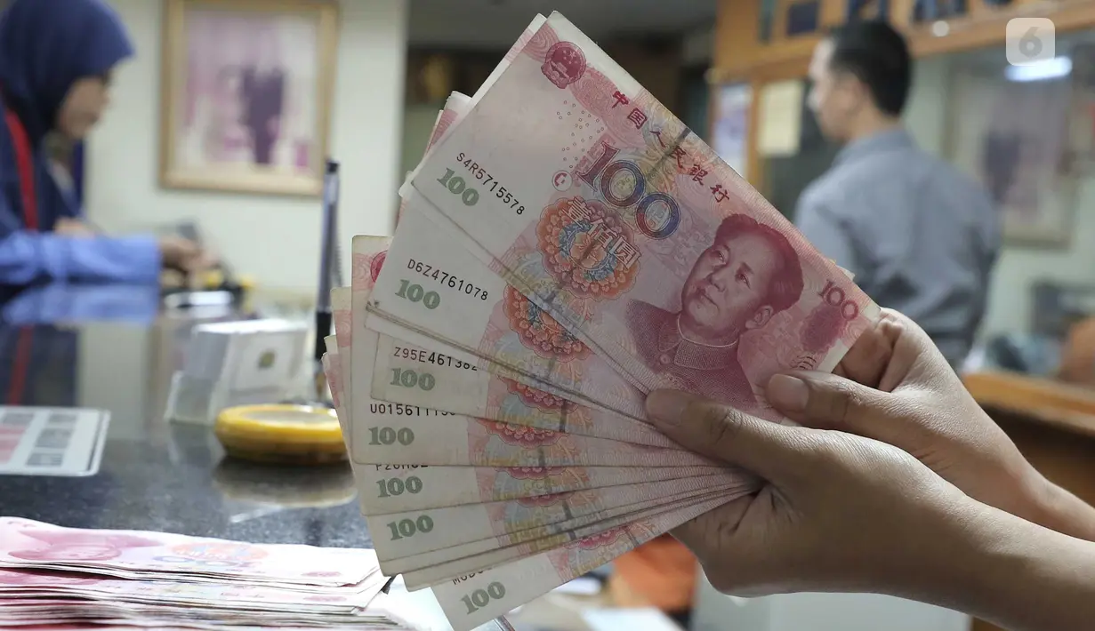 Seorang teller menunjukan  mata uang Yuan di Jakarta, Senin (30/11). Dana Moneter Internasional (IMF), Senin (30/11), resmi memasukan yuan, atau renminbi, ke dalam special drawing rights (SDR) sebagai mata uang elite dunia. (Liputan6.com/Angga Yuniar)