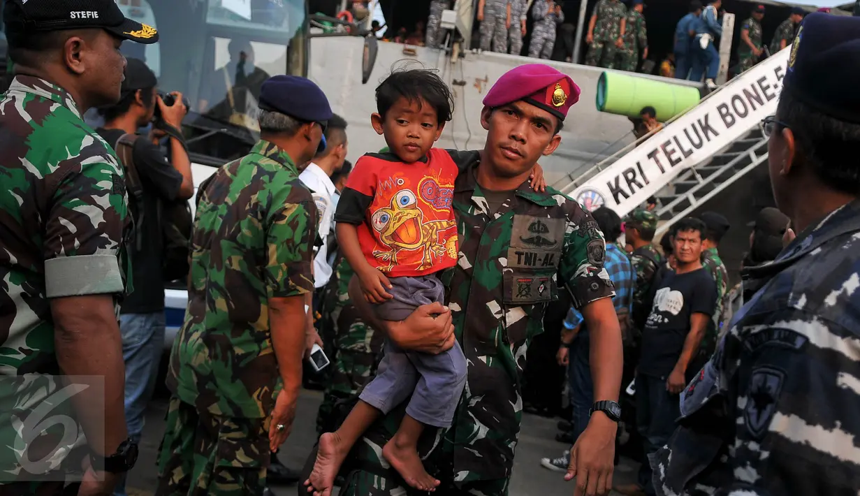 Seorang anggota TNI AD menggendong bocah dari keluarga eks Gafatar saat tiba di Tanjung Priok, Jakarta, Kamis (28/1/2016). Sebanyak 824 warga eks Gafatar dipulangkan dari Kalimantan untuk dikembalikan ke daerah asal. (Liputan6.com/Gempur M Surya)