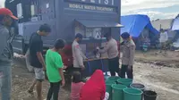 Personel Satbrimob Polda Sulteng sedang memasok air bersih menggunakan Mobil Water Treatment di lokasi pengungsian di Masamba pascabencana banjir bandang. (Foto: Bid. Humas Polda Sulteng).