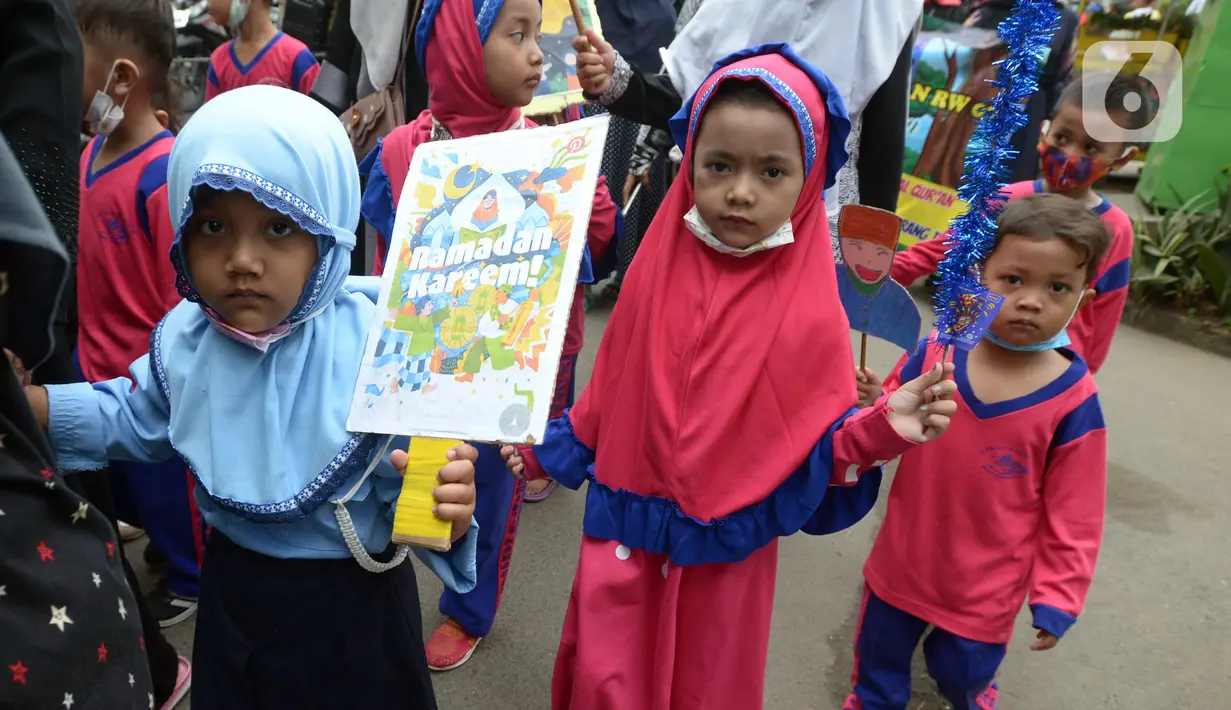 Sejumlah murid TK Islam membawa poster di Jalan Raya Radjiman Widyo Ningrat, Jakarta, Sabtu (26/3/2022). Pemerintah telah memperbolehkan melaksanakan kewajiban selama bulan suci Ramadan dengan protokol kesehatan yang ketat. (merdeka.com/Imam Buhori)