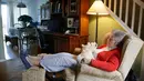 Mary Derr (93) duduk dengan robot kucing yang dipanggil "Buddy" di rumahnya, South Kingstown, 1 Desember 2017. Robot ini bisa berinteraksi serta memberikan respon dan cukup peka jika sang pemilik ingin bergurau dengannya. (AP/Stephan Savoia)
