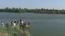 Sebuah keluarga berusaha melarikan diri dari kota Fallujah yang digempur pasukan pemerintah Irak, dengan menyebrangi Sungai Eufrat, 3 Juni 2016. ISIS kerap menggunakan ratusan keluarga di Fallujah sebagai perisai manusia dalam pertempuran. (REUTERS TV)