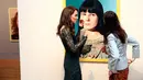 Kate Middleton berbincang dengan seniman Gillian Wearing saat pameran Portrait Gala 2017 di National Portrait Gallery, London (28/3). Kate tampil anggun mengenakan gaun berwarna hijau.  (Neil Hall/Pool photo via AP)