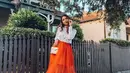 Gak harus formal, kamu bisa memadukan kemeja putihmu dengan rok tutu panjang warna oranye. Kelihatan fun! (Instagram/achasinaga).