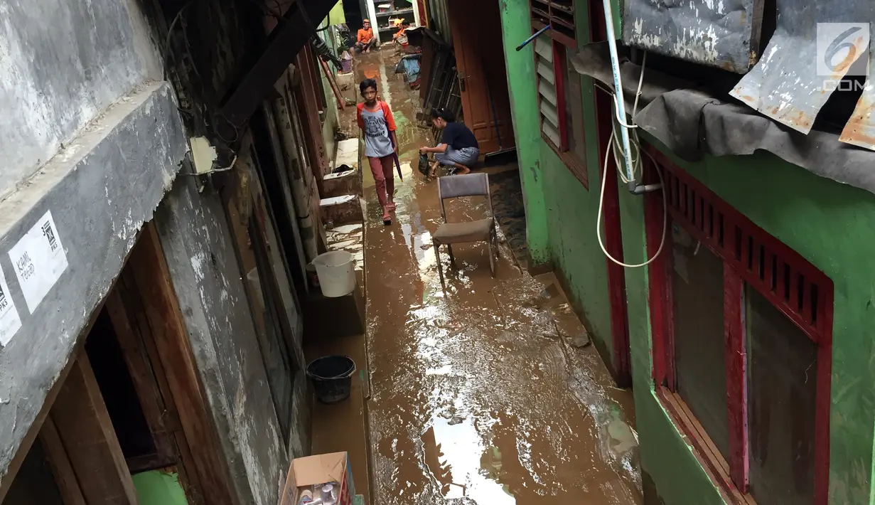 Seorang anak berjalan di antara gang becek karena lumpur sisa banjir yang menggenangi kawasan Rawajati, Jakarta Selatan, Selasa (6/2). Sebelumnya, banjir setinggi dua meter merendam kawasan tersebut. (Liputan6.com/Immanuel Antonius)