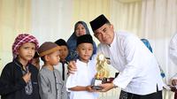 Penjabat (Pj) Wali Kota Tarakan, Bustan saat menyerahkan piala kepada santri berprestasi di halaman Kantor Kementerian Agama Tarakan, Selasa (22/10/2024). (Foto: Istimewa)