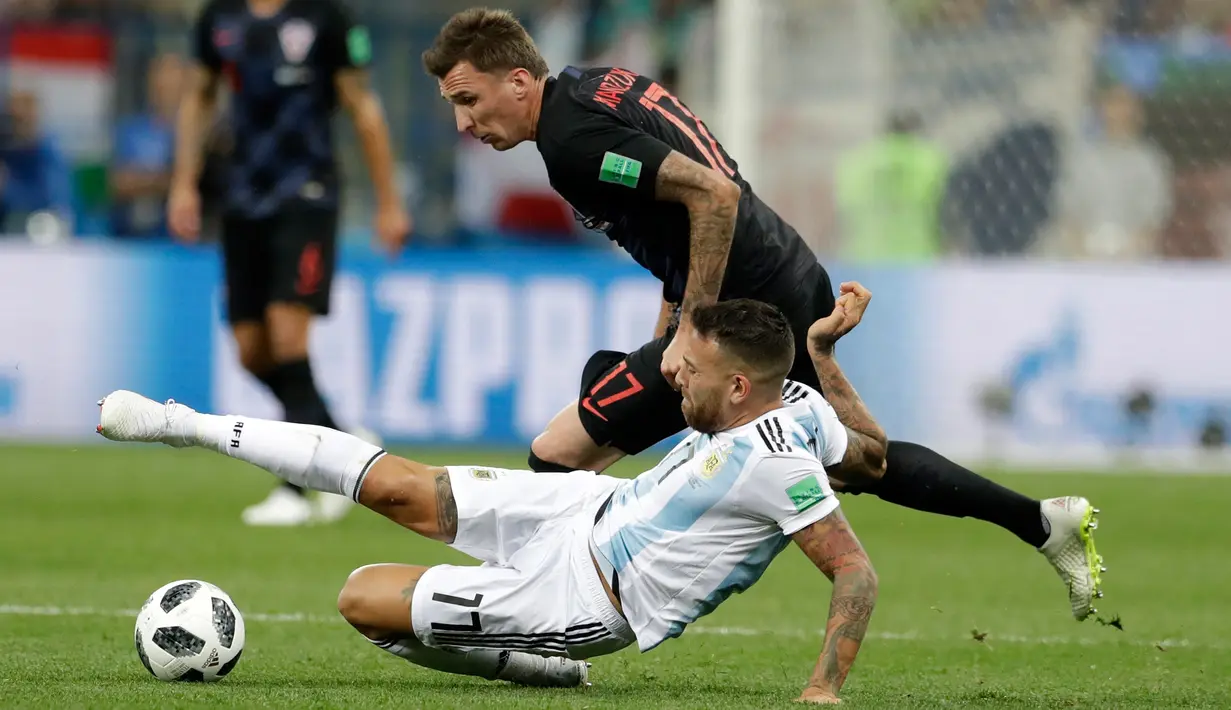 Pemain Argentina, Nicolas Otamendi mencoba menghentikan pemain Kroasia, Mario Mandzukic pada pertandingan Grup D Piala Dunia 2018 di Nizhy Novgorod Stadium, Rusia, Jumat (22/6). Menghadapi Kroasia, Argentina takluk dengan skor 0-3.. (AP/Petr David Josek)
