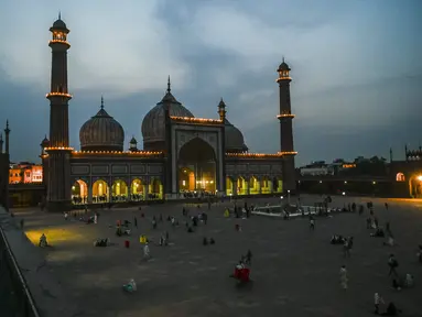 Umat Muslim berbuka puasa di masjid Jama Masjid pada hari pertama bulan suci Ramadhan, di New Delhi (14/4/2021). Masjid ini didirikan oleh Kaisar Mogul, Syah Jehan, yang juga membangun Taj Mahal. (AFP/Prakash Singh)