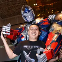 Augie Fantinus ceria berpose bersama Optimus Prime, salah satu tokoh Transformers (Galih W Satria/Bintang.com)