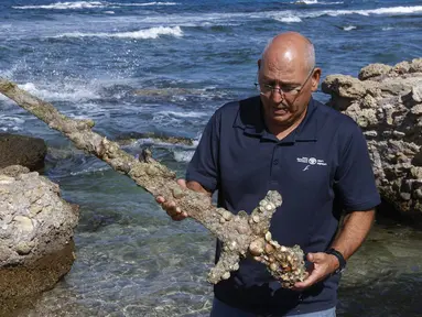 Jacob Sharvit dari Israel Antiquities Authority memperlihatkan pedang berusia 900 tahun yang diyakini milik seorang tentara salib di Caesarea pada 19 Oktober 2021. Seorang penyelam amatir menemukan pedang tersebut dari dasar laut Mediterania.  (JACK GUEZ / AFP)
