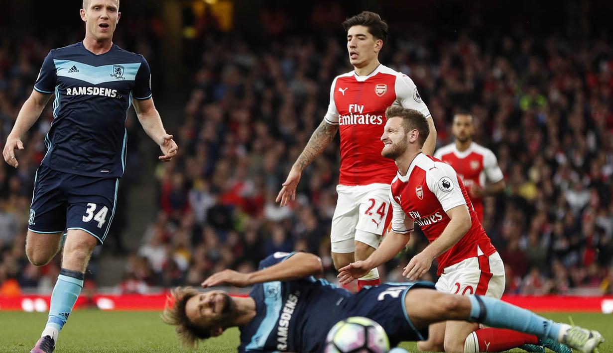Bek Arsenal, Shkodran Mustafi, terjatuh saat berebut bola dengan pemain Middlesbrough pada laga Premier League di Stadion Emirates, London, Sabtu (22/10/2016). (Reuters/John Sibley)