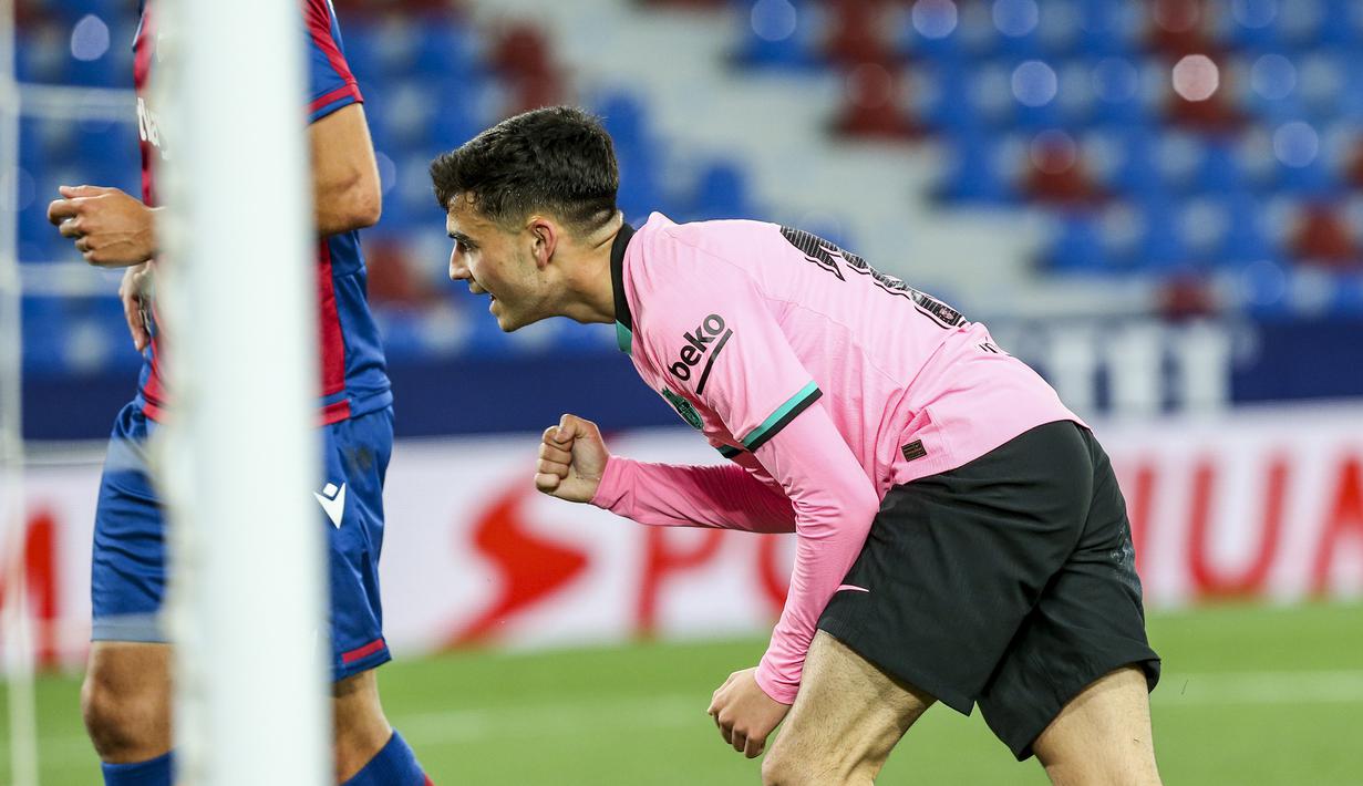 Gelandang Barcelona, Pedri melakukan selebrasi usai mencetak gol kedua timnya ke gawang Levante dalam laga lanjutan Liga Spanyol 2020/2021 pekan ke-36 di Ciutat de Valencia Stadium, Valencia, Selasa (11/5/2021). Barcelona bermain imbang 3-3 dengan Levante. (AP/Alberto Saiz)