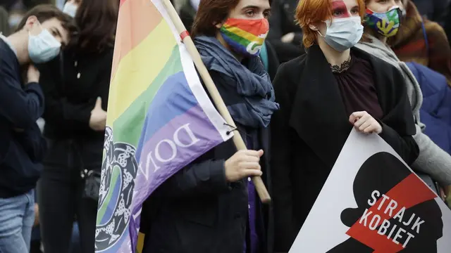 Aktivis hak-hak perempuan dengan poster memprotes pengetatan undang-undang aborsi ketat Polandia. (AP / Czarek Sokolowski)
