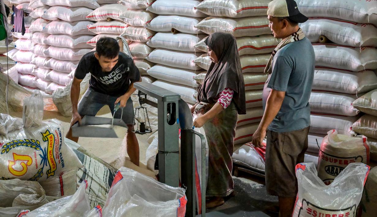 Para pekerja menyiapkan pesanan pelanggan di pasar beras utama di Jakarta pada Rabu 9 Juli 2025. (BAY ISMOYO/AFP)