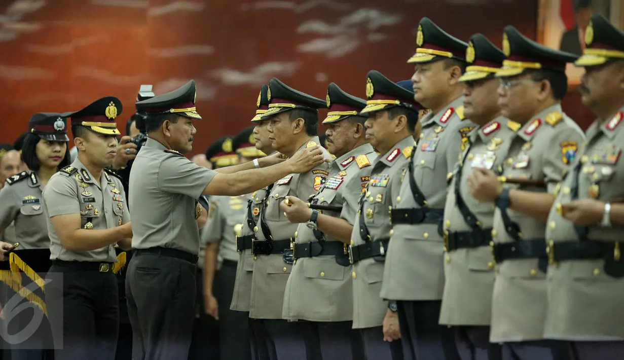 Kapolri Jenderal (Pol) Badrodin Haiti menyematkan lencana kepada Komjen Pol Anang Iskandar saat upacara sertijab di Aula Rupatama Mabes Polri, Jakarta, Senin (7/9). Anang resmi menjabat Kabareskrim menggantikan Budi Waseso. (Liputan6.com/Faizal Fanani)