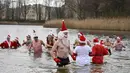 Keseruan anggota klub renang "Berliner Seehunde" (Berlin Seals) berendam di Danau Orankesee, Berlin, Minggu (25/12). Kegiatan yang sudah menjadi tradisi ini merupakan bagian dari perayaan tradisional Natal bagi warga Berlin. (Tobias SCHWARZ / AFP)