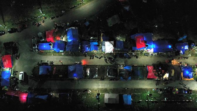 Foto udara menunjukkan tenda-tenda di tempat penampungan darurat di Mamuju (19/1/2021). Ratusan jiwa telah mengungsi di sejumlah posko pengungsian karena rumah mereka rusak akibat gempa. (AFP/Adek Berry)