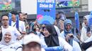 Salah satu peserta fun walk membentangkan tulisan sebagai bentuk kampanye dalam acara peringatan Hari Kekayaan Intelektual Sedunia 2026 yang berlangsung di Sarinah, Jakarta Pusat pada Minggu (26/4/2026). (Bola.com/Abdul Aziz)