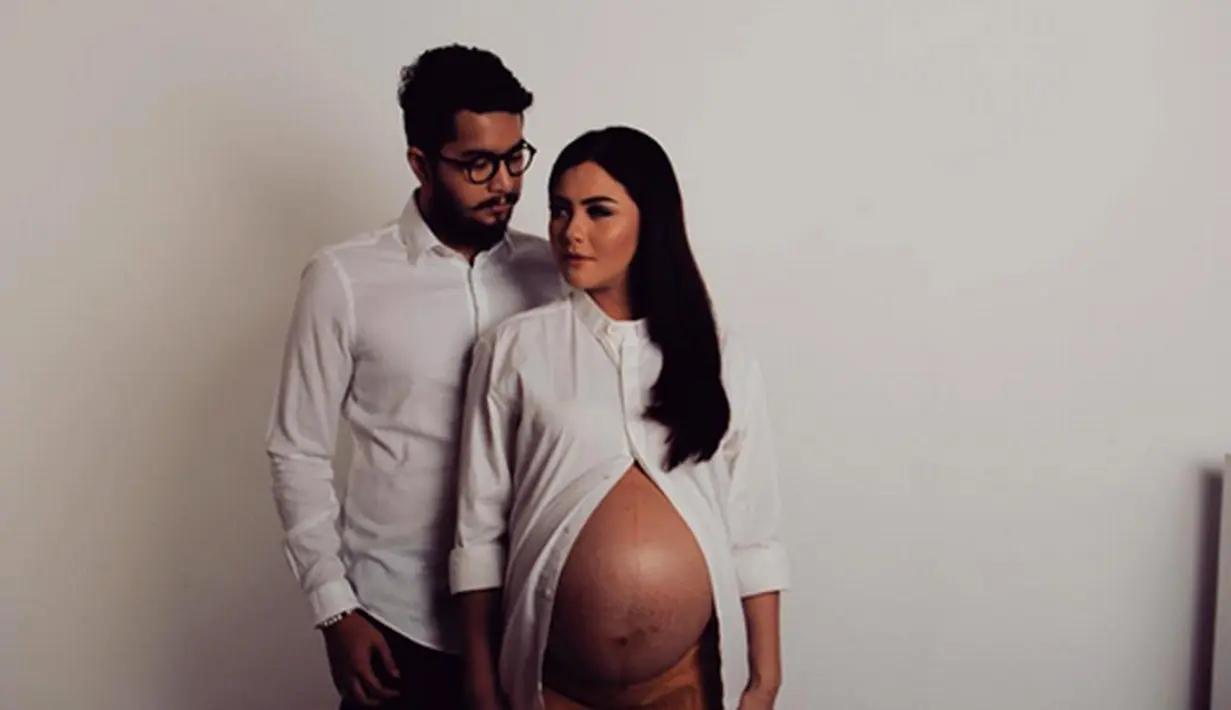 Awal Januari tahun ini, artis Revalina mengunggah foto kehamilannya bersama suaminya, Rendy Aditya. "Cant wait to see you baby R," tulis Reva. Tampil begitu cantik dengan mengenakan kemeja putih yang memperlihatkan perutnya. (Instagram)