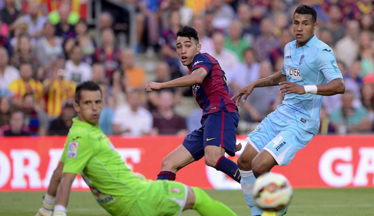 Penyerang Barcelona, Munir El Haddadi (tengah), mencoba memperdaya dua pemain Granada saat berlaga di lanjutan La Liga 2014 di Stadion Camp Nou, (27/9/2014). Barcelona unggul enam gol tanpa balas atas Granada. (AFP PHOTO/Josep Lago)