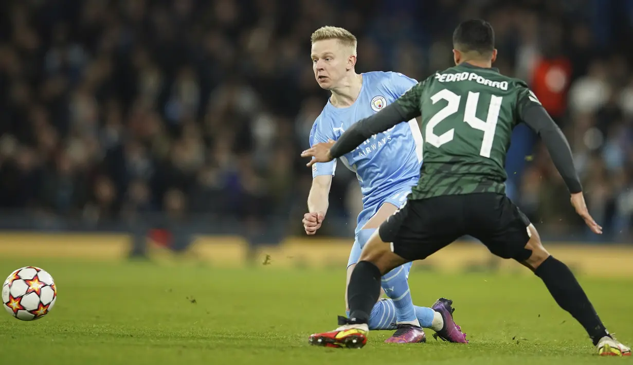Gelandang Manchester City Oleksandr Zinchenko berebut bola dengan bek Sporting Lisbon Pedro Porro pada leg kedua babak 16 besar Liga Champions, Kamis (10/3/2022) dini hari WIB. Manchester City tetap melaju ke perempat final meski bermain imbang 0-0 dengan Sporting Lisbon. (AP Photo/Dave Thompson)