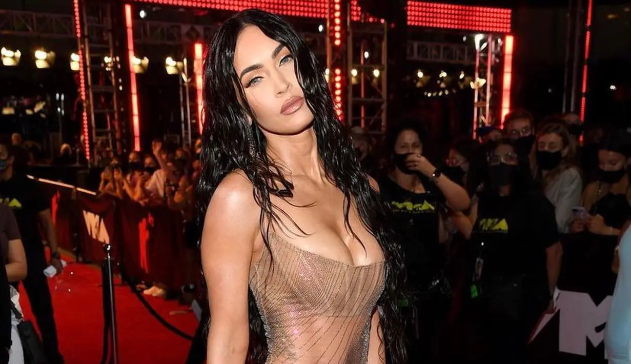 Berbalut koleksi Mugler, Megan tampil nyaris tanpa busana mengenakan bikini yang ditutupi dress sheer transparan. Penampilan wet-looknya memperkuat kesan seksinya di red carpet MTV VMA 2021. (Instagram/complex).