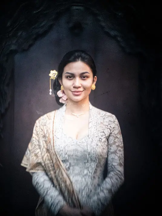 Ariel Tatum tampil memesona dengan kebaya putih dan kain batik sebagai selendang. Ia sempurnakan penampilannya dengan rambut yang disanggul dan diberi pemanis aksesori emas yang serasi. [Foto: Instagram/arieltatum]