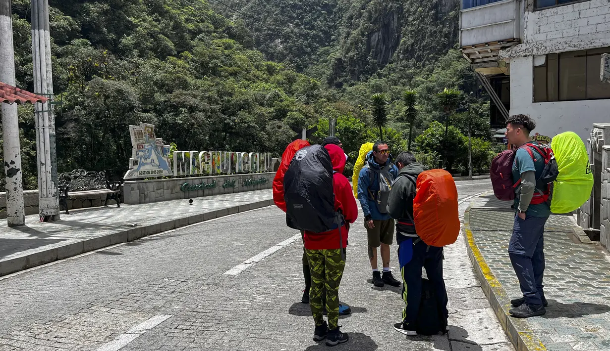 Turis menunggu di luar stasiun kereta Machu Picchu setelah layanan kereta api dihentikan karena kerusakan yang diduga disebabkan oleh pengunjuk rasa di Machu Picchu, Peru, Sabtu (21/1/2023). Puluhan orang telah terbunuh dengan demonstrasi penuh kekerasan yang terjadi selama beberapa pekan terakhir. (Photo by Carolina Paucar / AFP)