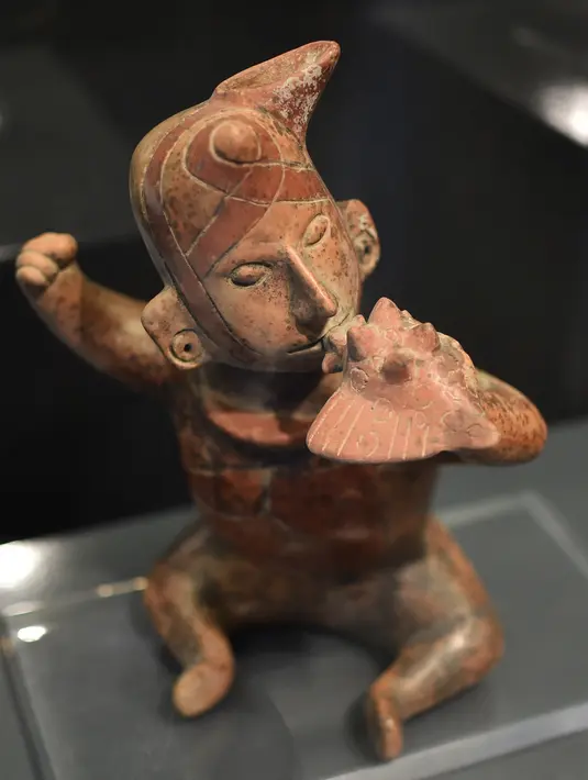 Patung Mesoamerika dari tradisi makam poros yang berasal dari 300 AC hingga 600 DC dipamerkan di Pusat Kebudayaan Universitas Tlatelolco di Mexico City (8/12/2021). (AFP/Rodrigo Arangua)