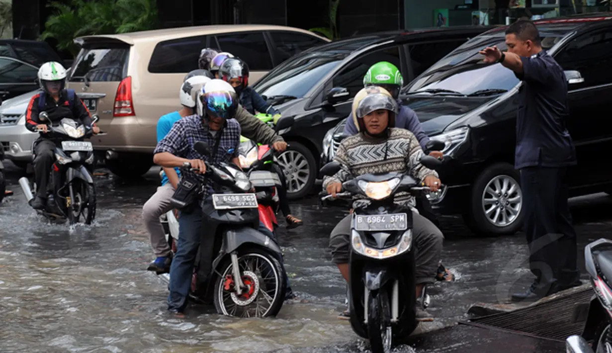 Hujan yang mengguyur Jakarta sejak Minggu (8/2/2015) mengakibatkan banjir di sejumlah wilayah. Pengendara melintasi sisi sebuah pertokoan untuk menghindari genangan air di jalan Kemang Raya, Jakarta, Selasa (10/2/2015). (Liputan6.com/Helmi Fithriansyah)