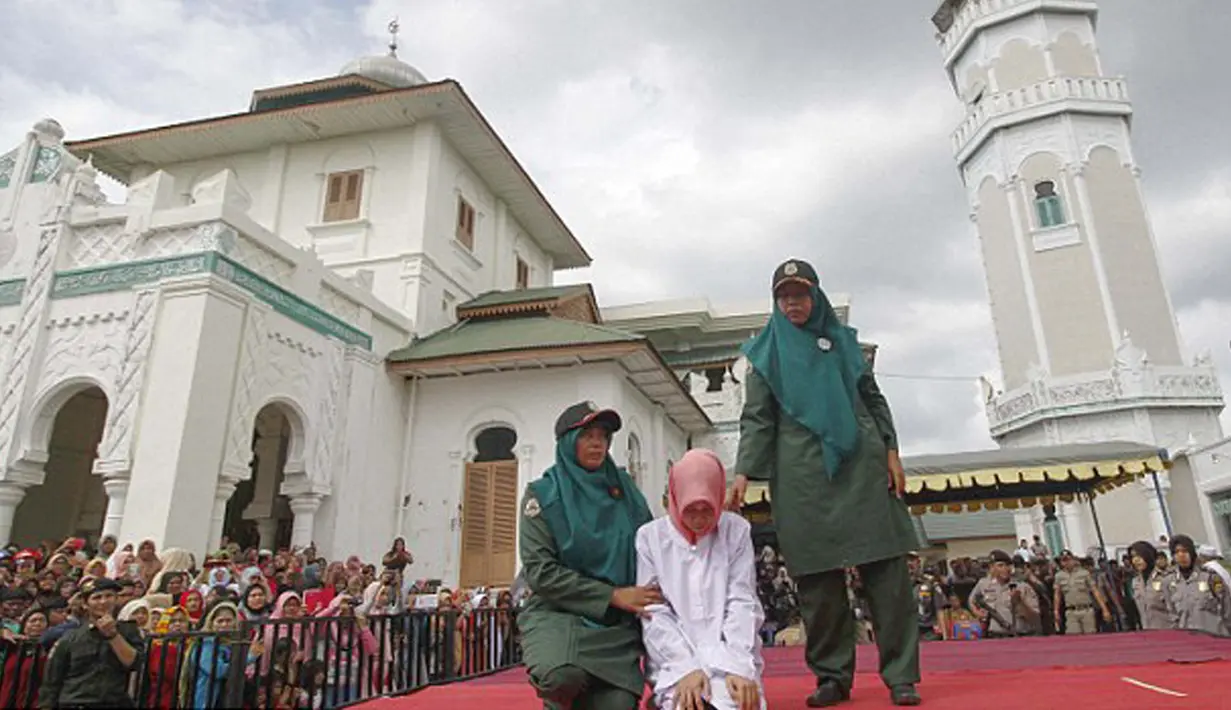 Nur Elita, terpidana pelanggar hukum syariat bersiap menjalani eksekusi hukuman cambuk di halaman Masjid Baiturrahim, Ulee Lheue, Banda Aceh, Senin (28/12). Nur yang merupakan terpidana kasus khalwat mendapat 5 kali cambukan (Jefta Images/dailymail.co.uk)