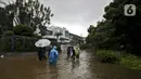 Warga beraktivitas diarea lingkungannya yang tergenang banjir di Jalan Hang Lekir, Kebayoran Lama, Jakarta Selatan, Rabu (1/1/2020). Banjir tersebut disebabkan karena tingginya intensitas hujan yang mengguyur sejak Selasa (31/12/2019). (Liputan6.com/Johan Tallo)