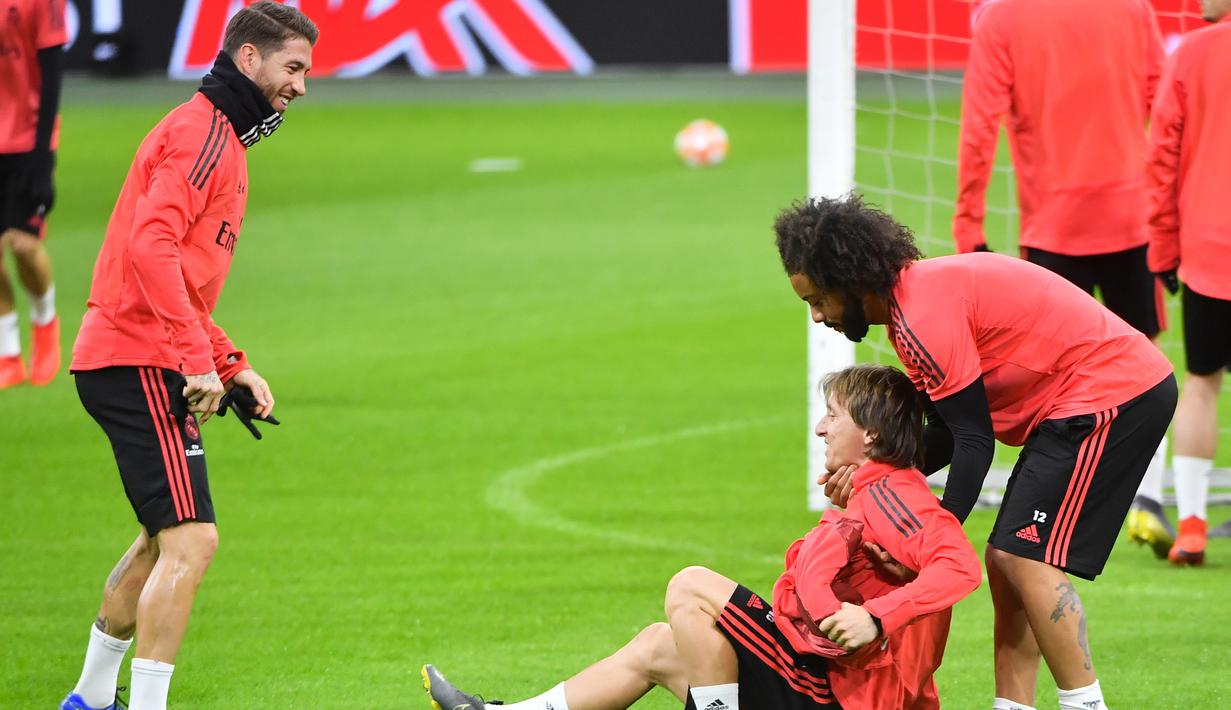 Bek Real Madrid, Marcelo, mengangkat Luka Modric, saat latihan jelang laga Liga Champions 2019 di Johan Cruijff Arena, Selasa (12/2). Real Madrid akan berhadapan dengan Ajax Amsterdam. (AFP/Emmanuel Dunand)