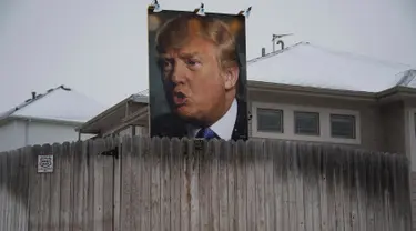Sebuah Baliho raksasa calon Presiden dari Partai Republik Donald Trump terpampang di halaman belakang rumah George Davey di West Des Moines, Iowa, (25/1/2016).  (AFP/JIM WATSON)