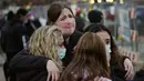 Warga saling menghibur di sepanjang pagar yang dipasang di sekitar tempat parkir tempat penembakan massal terjadi di toko King Soopers di Boulder, Colorado (23/3/2021). (AP Photo/David Zalubowski)