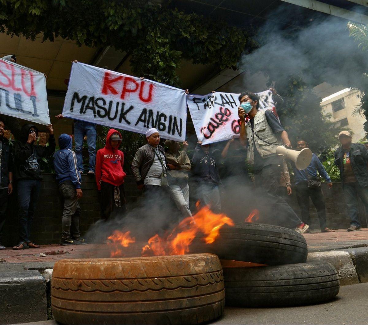 Massa dari Aliansi Calon Anggota Legislatif Partai Golkar Dapil 8 Provinsi DKI Jakarta melakukan aksi bakar ban bekas di pinggir jalan. Foto merdeka.com / Arie Basuki<br>