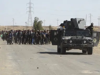 Pasukan tentara Irak mengawal puluhan warga yang melarikan diri setelah terjadi pertempuran antara pasukan Irak dan militas ISIS di kota Hit, provinsi Anbar, (5/4/2016). (REUTERS/Stringer)
