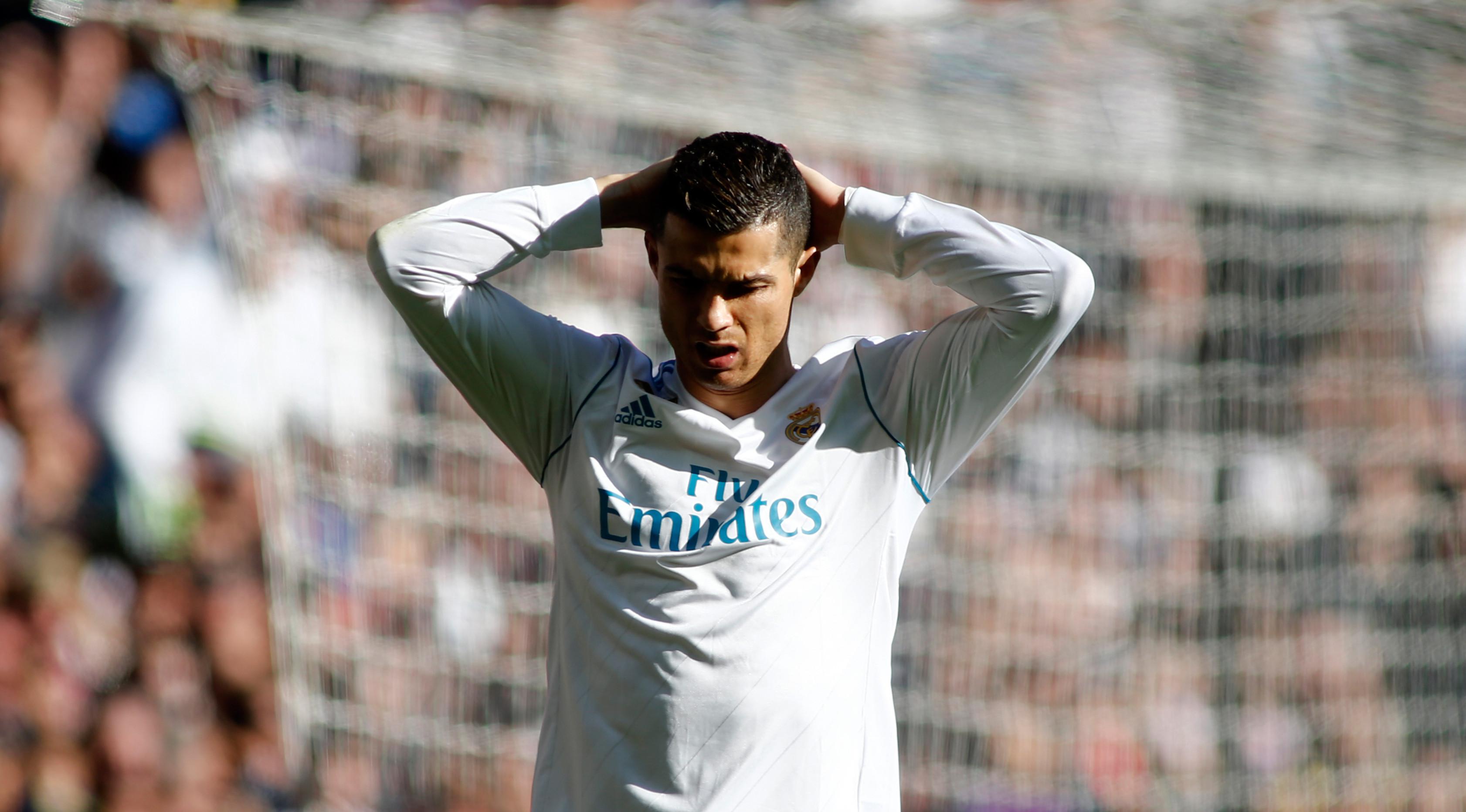Ekspresi penyerang Real Madrid Cristiano Ronaldo saat melawan Barcelona dalam pertandingan Liga Spanyol di stadion Santiago Bernabeu di Madrid, Spanyol (23/12). Madrid harus menelan kekalahan atas Barcelona dengan skor 0-3. (AFP Photo/Oscar Del Pozo)