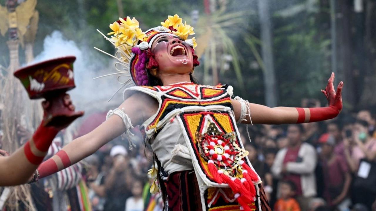 Mereka juga bersorak dengan mengeluarkan suara yang keras untuk mengusir roh jahat. Foto: AFP / SONNY TUMBELAKA<br>