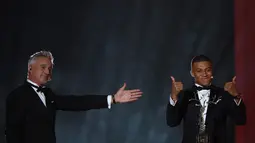 Striker PSG, Kylian Mbappe (kanan) bereaksi setelah menerima penghargaan Trophee Kopa pada seremoni Ballon d'Or 2018 di Paris, Senin (3/12). Mbappe menjadi pemain pertama dalam sejarah yang memenangi penghargaan Trophee Kopa. (FRANCK FIFE/AFP)