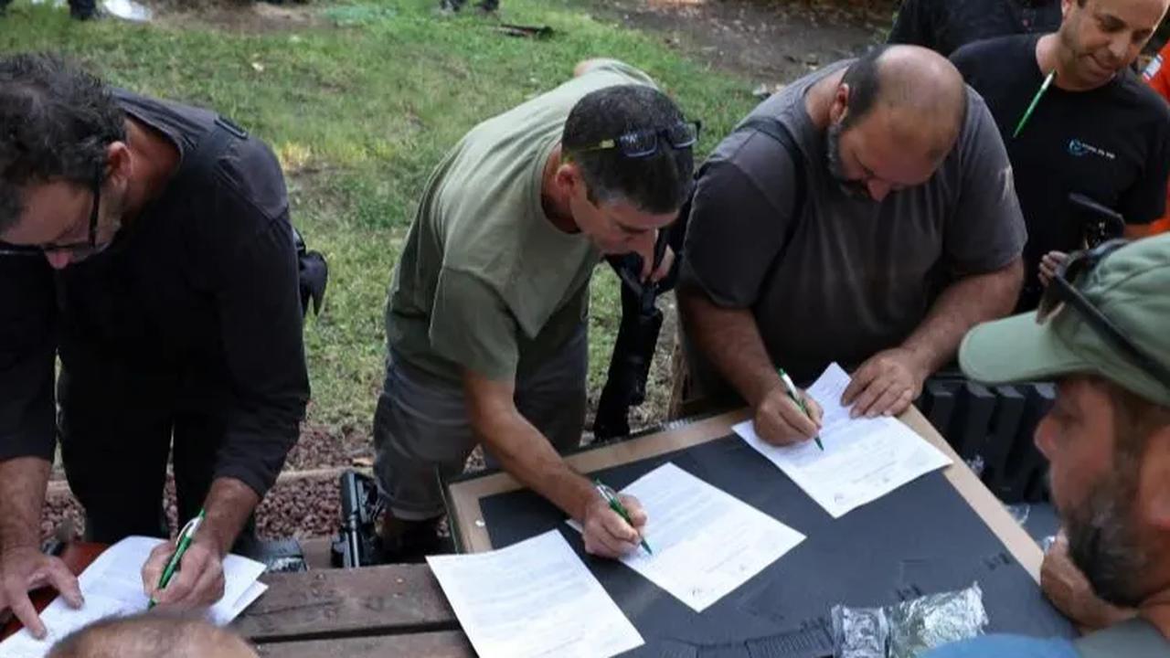 Warga Israel yang sudah tiba di Ayyelet HaShahar Kibbutz langsung mendaftar dengan menulis data dirinya untuk menerima senjata yang sudah disiapkan.<br>