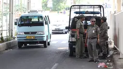 Personel Satpol PP berjaga di bawah skybridge Tanah Abang, Jakarta, Selasa (8/1). Penjagaan tersebut dilakukan untuk mencegah PKL yang berjualan di sekitar Stasiun Tanah Abang. (Liputan6.com/Immanuel Antonius)