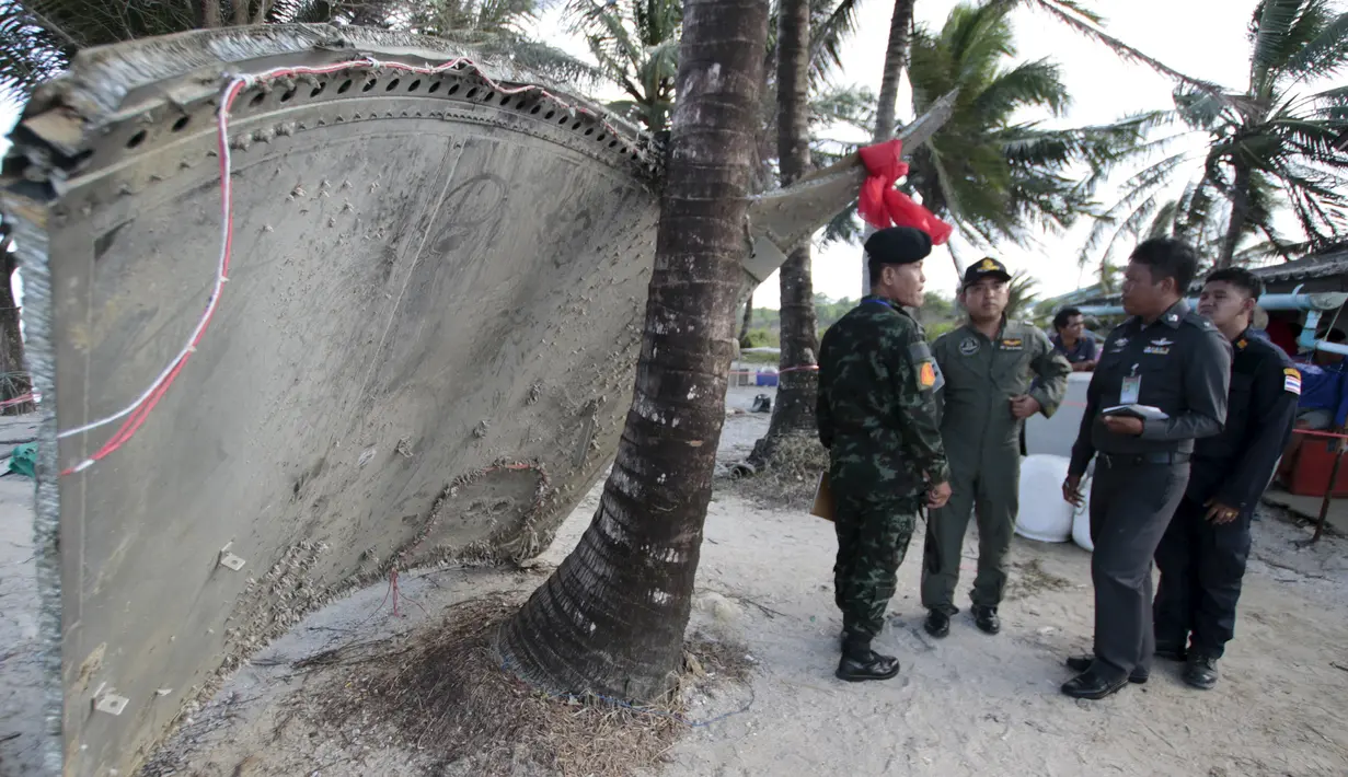 Tentara berdiri di dekat potongan pesawat yang ditemukan di pantai Thailand selatan, Minggu (24/1). Sebuah bagian pesawat yang diduga dari pesawat Malaysia Airlines MH370 terdampar di pantai provinsi Nakhon Si Thammarat. (REUTERS/Surapan Boonthanom)