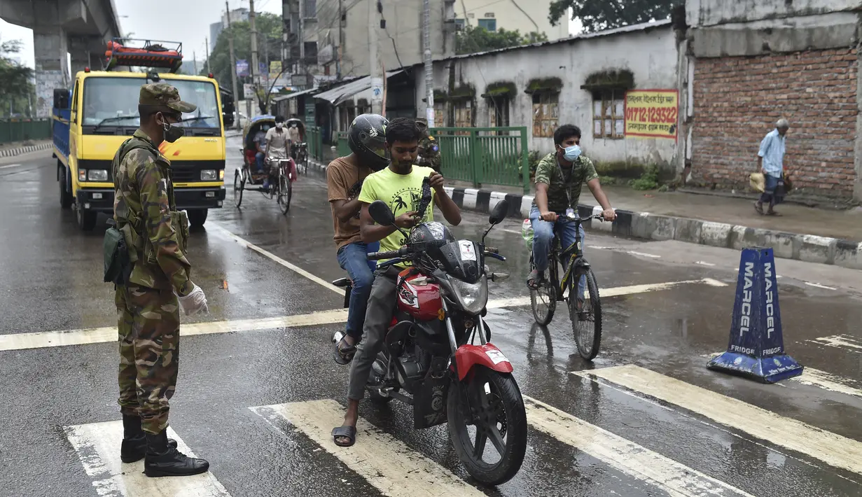 Tentara Bangladesh menjaga pos pemeriksaan sepanjang jalan di Dhaka, Bangladesh, Kamis (1/7/2021). Mulai 1 Juli diberlakukan lockdown, Tentara dan Polisi Bangladesh diperintahkan untuk menghentikan orang-orang yang meninggalkan rumah mereka kecuali untuk keadaan darurat. (AFP/Munir Uz zaman)
