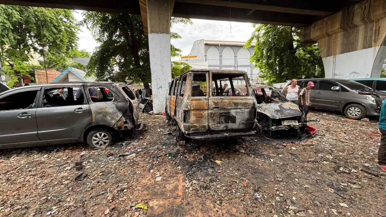 Mobil terbakar di kolong rel kereta api kawasan Karang Anyar, Sawah Besar, Jakarta Pusat.