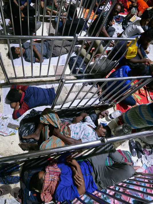 Orang-orang Bangladesh tidur saat mengantre untuk mendapatkan tiket  mudik lebaran di Stasiun Kereta Kamalapur, Dhaka, Kamis (23/5/2019). Sama halnya dengan Indonesia, mudik menjelang Lebaran merupakan salah satu tradisi terbesar tahunan di Bangladesh. (MUNIR UZ ZAMAN/AFP)