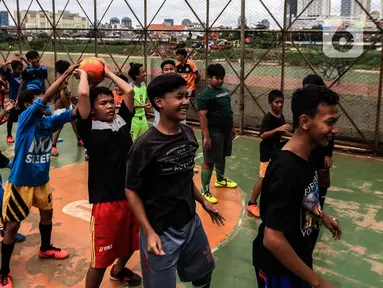 Anak-anak berlatih sepak bola di lapangan samping Banjir Kanal Barat (BKB), Jakarta, Kamis (7/1/2020). Revitalisasi jalur hijau di sepanjang aliran BKB menyulap kawasan kumuh menjadi tempat interaktif warga sekitar yang dilengkapi fasilitas bermain, seperti lapangan futsal. (Liputan6.com/Johan Tallo