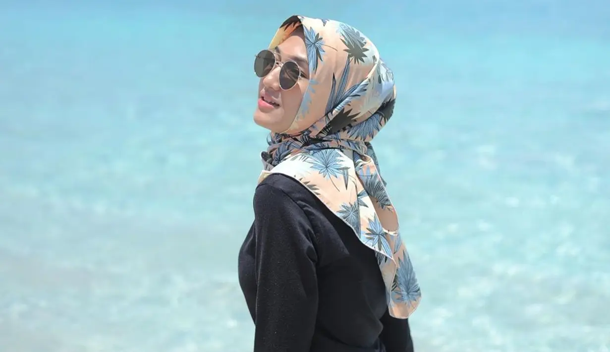 Nikmati keindahan pantai rasanya ada yang kurang jika tidak mengenakan kacamata hitam. Selain menunjang penampilan, kacamata tersebut dapat melindungi mata dari sinar matahari langsung. Kenakan kacamata, penampilan Naya jadi makin menarik ketika jepretan foto diambil. (Liputan6.com/IG/@afnaalliya_)