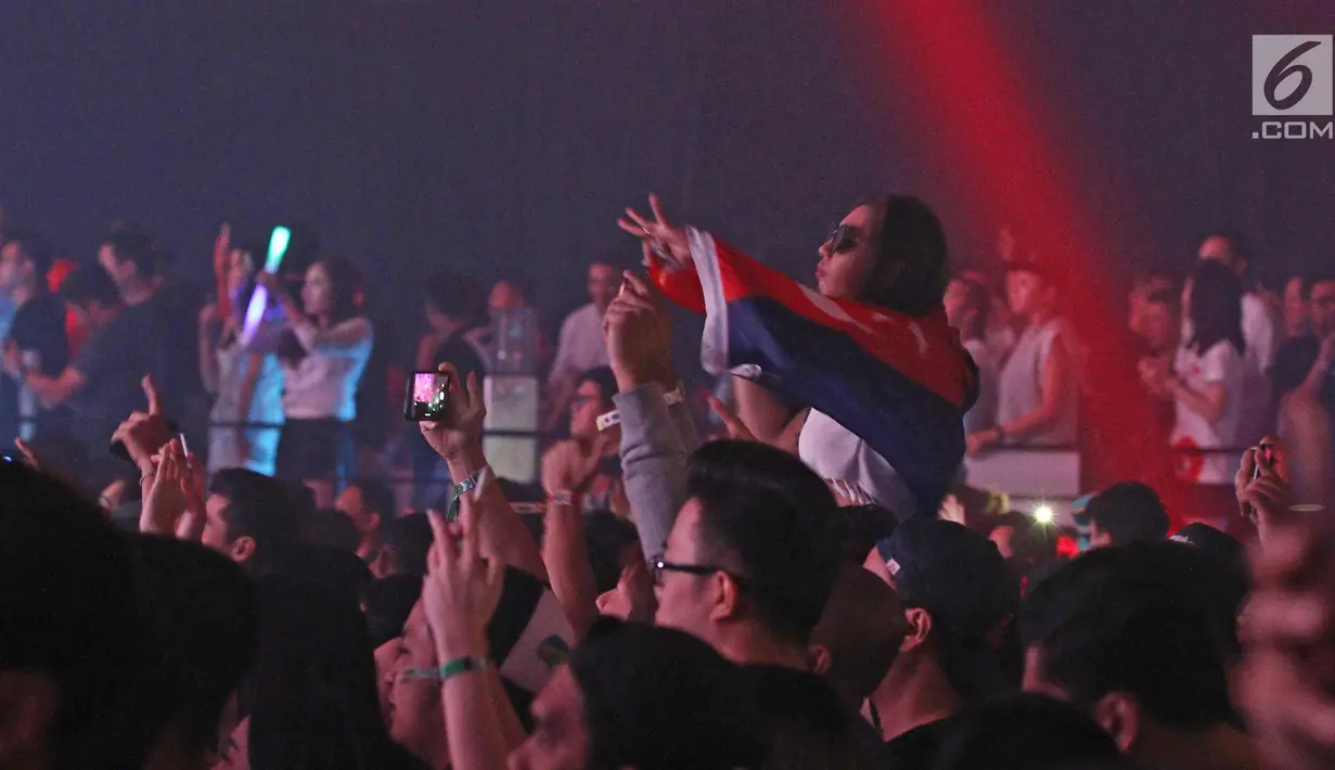 Seorang penonton menikmati musik dalam acara Invasion 2017 yang bertajuk Lost In Wonderland di Jakarta, Jumat (22/9). Sejumlah DJ dunia menghibur para party goers Indonesia. (Liputan6.com/Herman Zakharia)