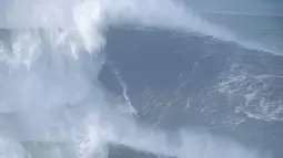 Justine Dupont, dari Prancis, mengendarai ombak saat sesi selancar ombak besar di Praia do Norte, Nazare, Portugal, Sabtu (8/1/2022).   Para peselancar menaklukkan ombak raksasa setinggi gedung pencakar langit yang dihasilkan ngarai bawah laut terbesar di Eropa. (AP Photo/Armando Franca)